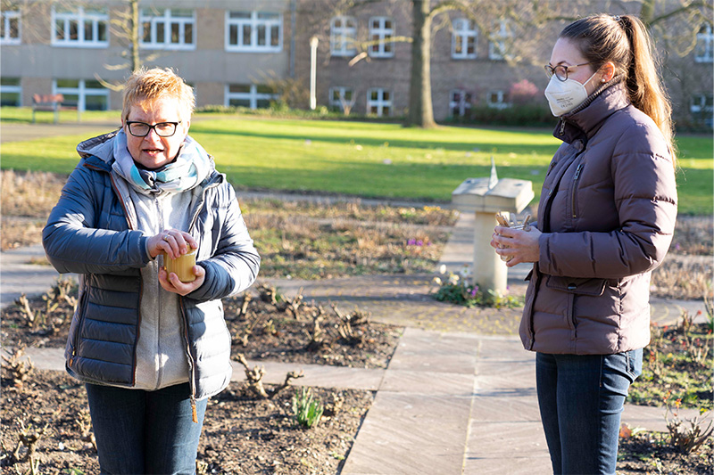 Imkerin Andrea Lenzmeier (links) bot bei der „Bienen-Aktion“ im Mutterhausgarten mehrere Honigsorten zur Verkostung an. Pastoralassistentin Tanja Espinosa (rechts) stellte von der Natur der Bienen Bezüge zum christlichen Glauben her. Foto: Michael Bodin / fcjm-presse