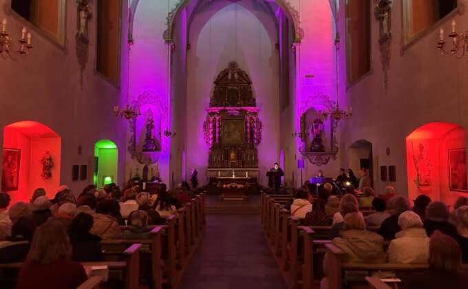 Die schön beleuchtete Kirche lud zu Beginn und Ende der Veranstaltung zu Impulsen mit musikalischer Begleitung ein. © J. Schumacher / Dekanat Paderborn